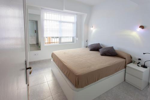 サロウにあるApartamento Miramarの白いベッドルーム(ベッド1台、窓付)