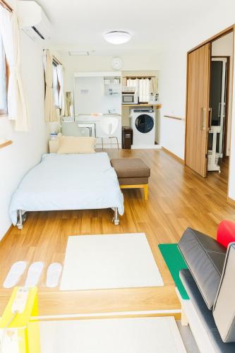 a living room with two beds and a couch at Barrier Free Guesthouse Support Include Free Parking Near AEON Mall in Osaka