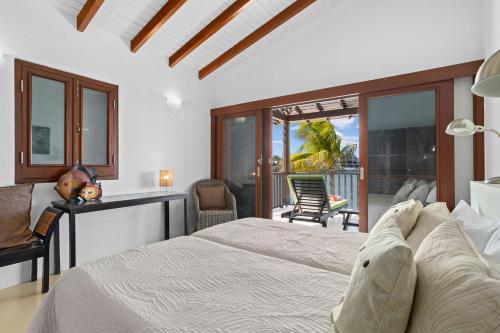 ein Schlafzimmer mit großem Bett und Balkon in der Unterkunft Waterlands Village Bonaire - Oceanview Villa 9 in Kralendijk