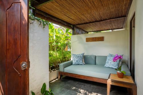 a couch on the porch of a house at Rama Residence Petitenget in Seminyak