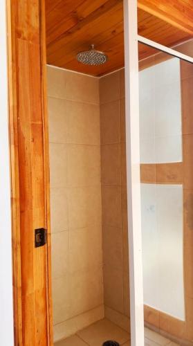a shower with a glass door in a bathroom at Refugio Campestre, Cabaña con Tinaja Opcional 
