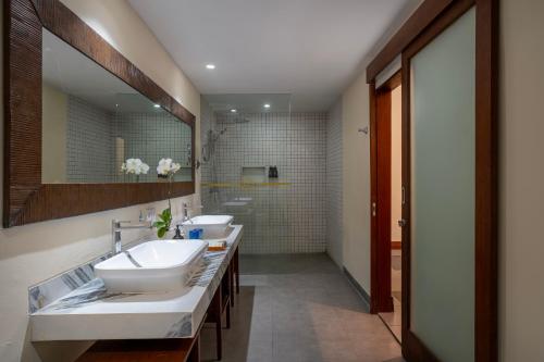 a bathroom with two sinks and a large mirror at Rama Residence Petitenget in Seminyak