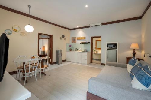a living room with a couch and a table and a kitchen at Rama Residence Petitenget in Seminyak