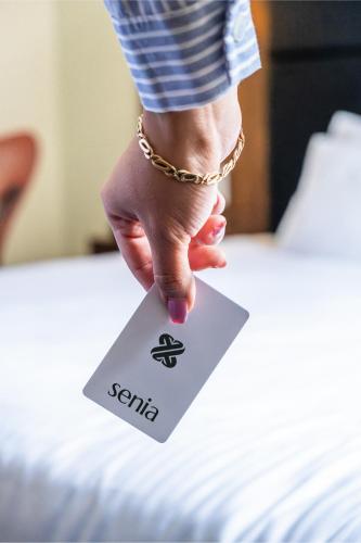a person holding a tag on a bed at Senia Reforma in Mexico City