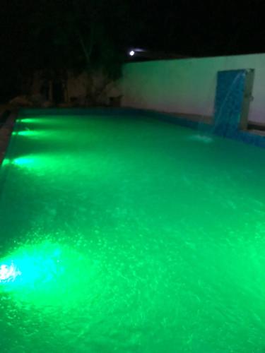 a pool filled with green water at night at Ovenro Hotel Yala, Kataragama in Kataragama