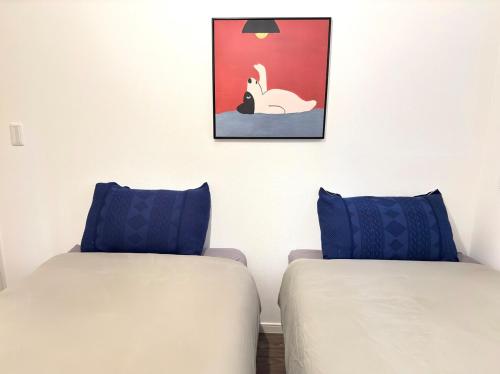 two beds with blue pillows in a room at The YAMAGUCHI in Inzai