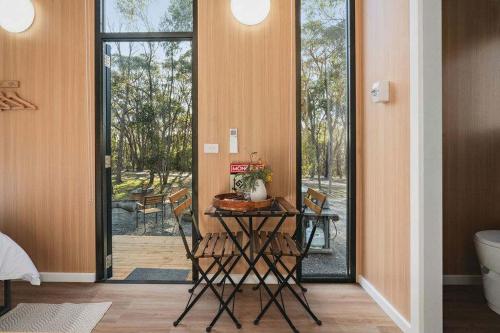 Habitación con mesa, sillas y bañera. en Black Forest Hide Away by Tiny Away, en Macedon