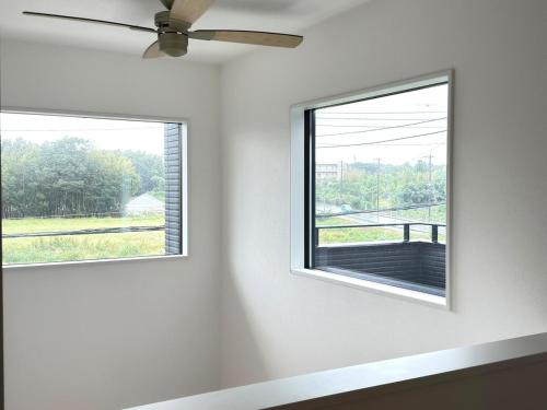 two windows in a white room with a ceiling fan at The YAMAGUCHI in Inzai