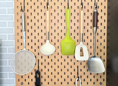 a wall with many pots and pans and spatulas at The YAMAGUCHI in Inzai