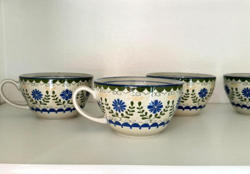 four blue and white cups sitting on a shelf at The YAMAGUCHI in Inzai