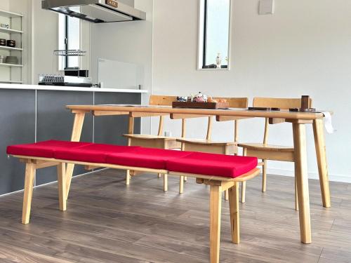 a dining room table with a red cushioned bench at The YAMAGUCHI in Inzai