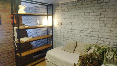 Zimmer mit einem Bett und einer Ziegelwand in der Unterkunft Casa Grande con pileta próximo kempes, ferial, Córdoba in Cordoba