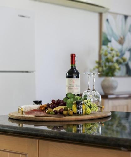 a bottle of wine and a plate of food and wine glasses at 10/17 Richardson Street, South Perth in Perth