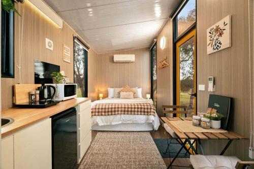a small bedroom with a bed in a tiny house at Sheryl's Place by Tiny Away