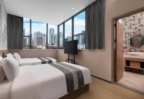 a bedroom with a large bed with a view of the city at Days Inn by Wyndham Zhuhai Qinglv Road in Zhuhai