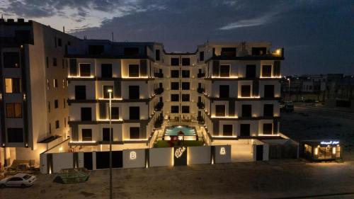 a large white building with lights in front of it at Sohob Compound in Al Khobar