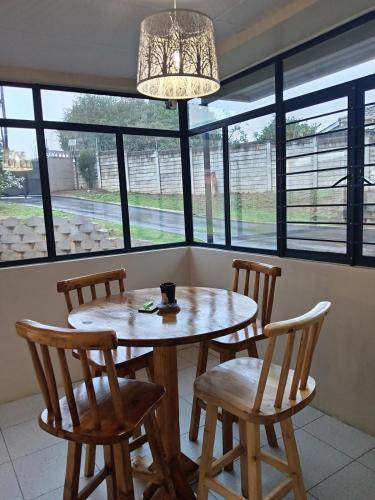 a table and chairs in a room with windows at The Deyzel house in Durban