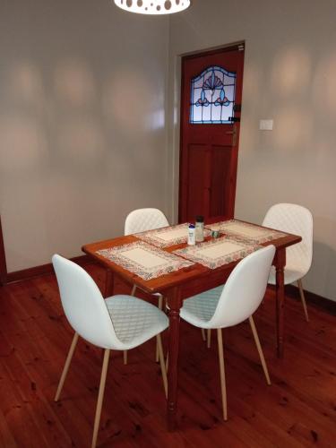 a dining room table with white chairs and a window at The Deyzel house in Durban