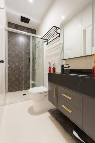 a bathroom with a toilet and a glass shower at Stylish 4BR Easy CBD Access Walk to Train & Shops in Melbourne
