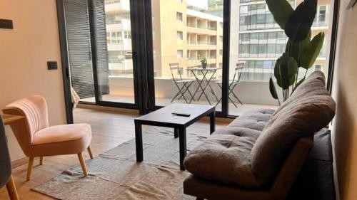 uma sala de estar com um sofá e uma mesa em Exclusive Fully Equipped Apartment in Las Condes em Santiago