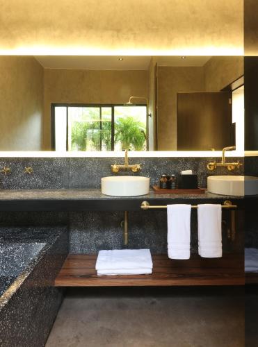 a bathroom with two sinks and two mirrors at Aposento Boutique Hotel in Mexico City