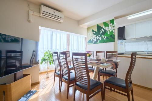 une salle à manger avec une table et des chaises dans l'établissement A-Shinjuku BigRoof Balcony, 6BedRoom,140sqm House for 20ppl,4min to Yotsuya-Sanchome Sta, à Tokyo