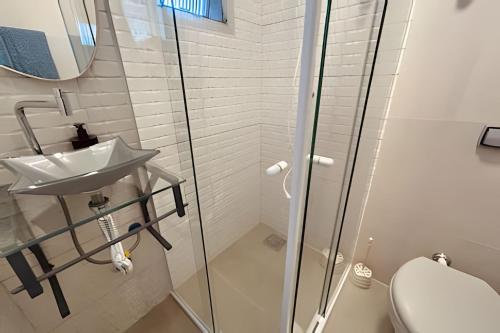 a bathroom with a sink and a shower at Melhor local de Pitangueiras com serviço de praia in Guarujá