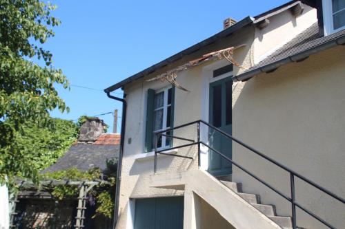 a building with a staircase next to a window at Apartment Fleur de Lys Bleue in Soudaine-Lavinadière
