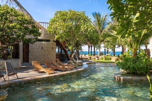 a pool with chairs and the ocean in the background at Sun Village in Tuy Hoa