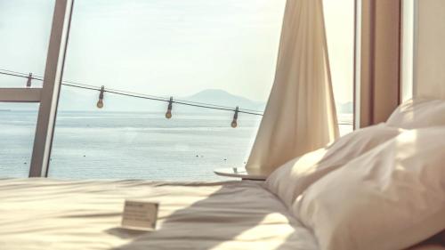a bedroom with a bed with a view of the ocean at Namhae Pumda Pool villa Pension in Namhae