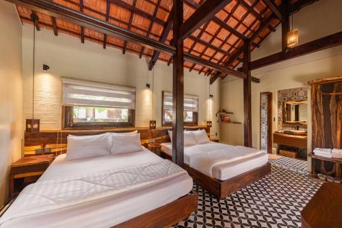 a bedroom with two beds and a bathroom at Sun Village in Tuy Hoa
