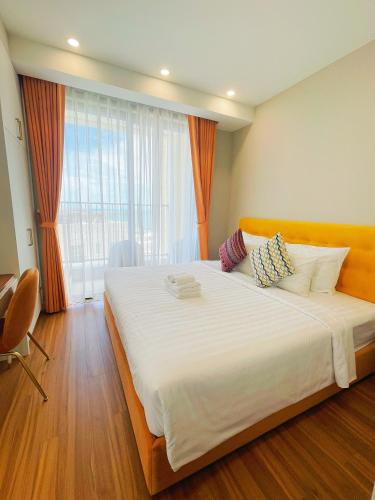 a large bed in a room with a large window at We Young Apartments by HOFs - Fireworks & Ocean view in Phú Quốc