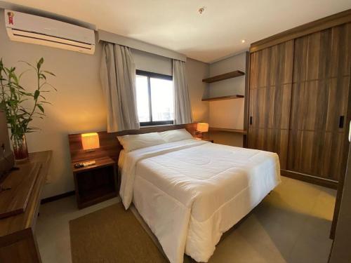 a bedroom with a white bed and a window at Ed. Connext Loft (ref. Hotel Mercure Boulevard) in Curro Velho