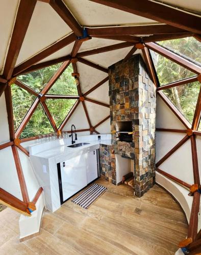 a kitchen with a sink and a stone fireplace at Domo Real in Nova Friburgo