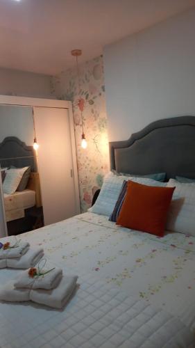 a bedroom with a large bed with towels on it at Apartamento Le Quartier - no centro, dois quartos, wi-fi, garagem, piscina, ar-condicionado, jacuzzi, sauna, etc in Juiz de Fora