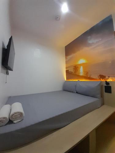 a room with a bed with a painting on the wall at Happy Island Inn in Virac