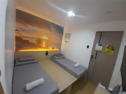 a room with two beds and a painting on the wall at Happy Island Inn in Virac