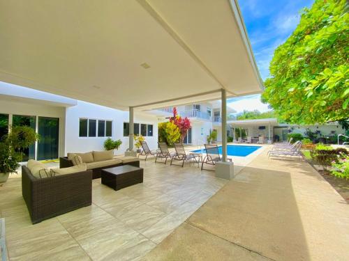 an outdoor patio with a couch and chairs and an umbrella at Uvita Paradise in Uvita