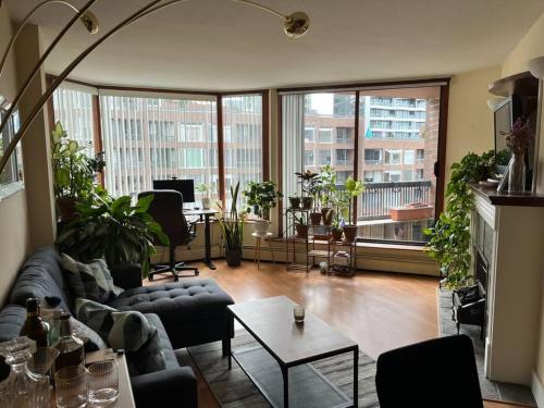 een woonkamer met een bank en een tafel bij Harbor Light-Modern 1BR King-Complete Unit in Vancouver