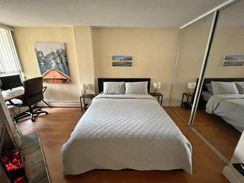 een slaapkamer met een groot wit bed en een bureau bij Harbor Light-Modern 1BR King-Complete Unit in Vancouver