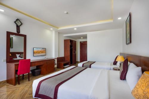 a bedroom with a bed and a desk with a red chair at Gem Nha Trang Hotel in Nha Trang