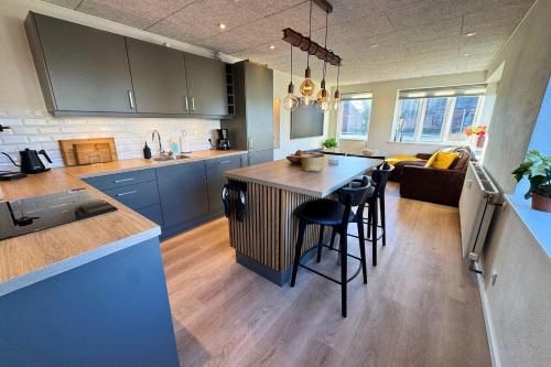 a kitchen with a island in the middle of a room at Cozy & Modern Living in Central Odense in Odense