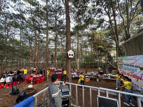 a group of people standing around a tree with a crowd at SAKURA HOMEsTAY MĂNG ĐEN in Kon Plong