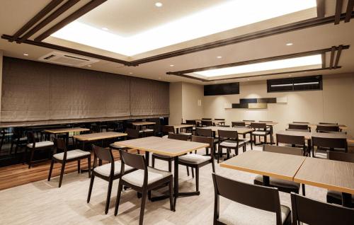 a dining room with tables and chairs and a chalkboard at HOTEL AMANEK HidaTakayama in Takayama