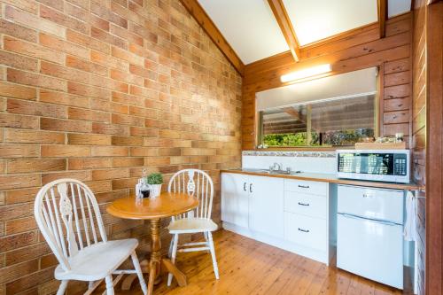 a kitchen with a table and chairs and a brick wall at Sabo’s On Severn in Fletcher