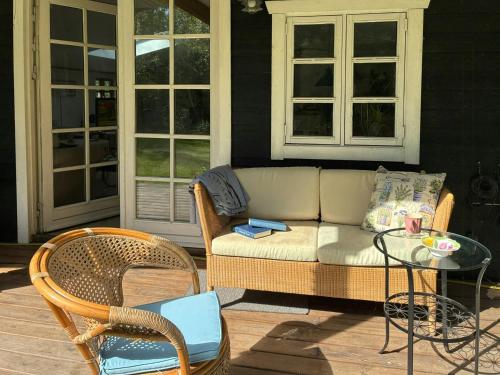 a couch and chairs on a porch with a table at Summerhouse Near Marielyst Beach With Large Garden in Marielyst