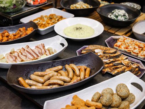 a table topped with plates of food and bowls of food at HOTEL AMANEK HidaTakayama in Takayama