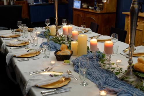 a long table with candles and plates and glasses at Sabo’s On Severn in Fletcher