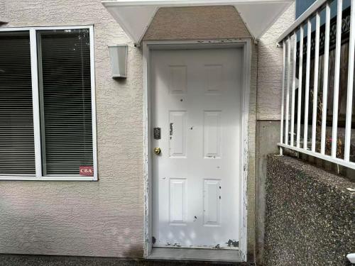 a white front door of a house with a staircase at UBC Two-Bedroom Suite - Steps from Beach, Park & Golf - Full Kitchen in Vancouver