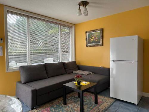 a living room with a couch and a refrigerator at UBC Two-Bedroom Suite - Steps from Beach, Park & Golf - Full Kitchen in Vancouver